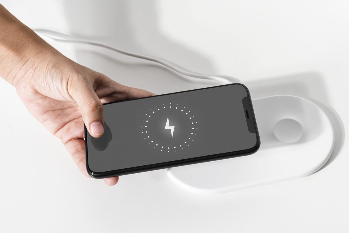 Hand connecting smartphone to wireless charger
