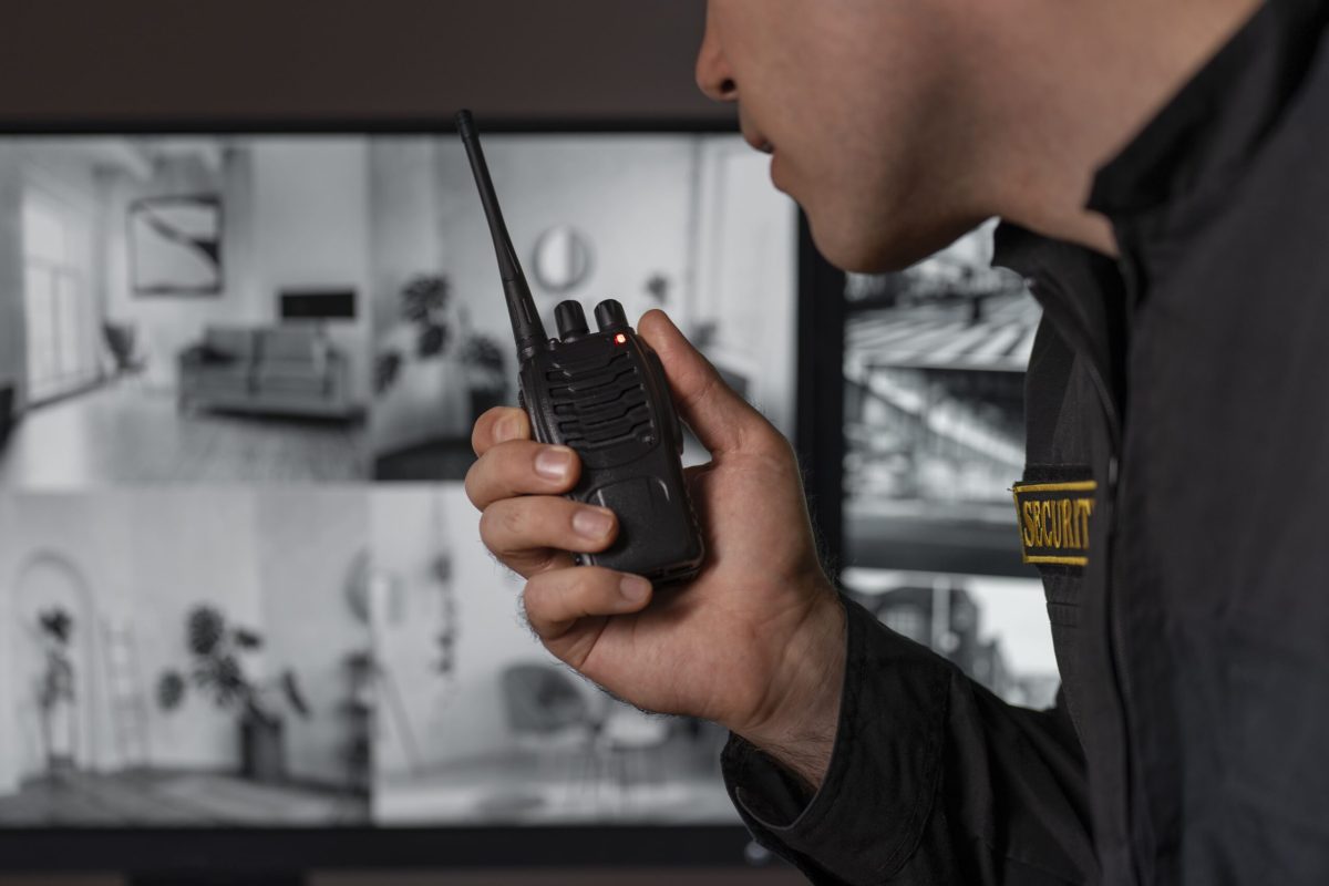 portrait-male-security-guard-with-radio-station-camera-screens-min